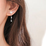 Maren – Gold earrings with dangling pearls.