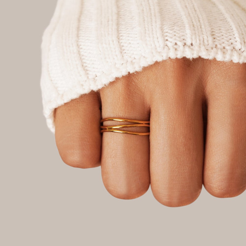 Valerie – Gold ring with intertwined line design.