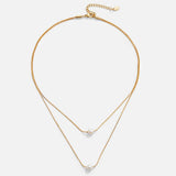 Sabina – Double layer gold chain with dark stone.