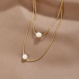 Sabina – Double layer gold chain with dark stone.