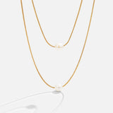 Sabina – Double layer gold chain with dark stone.