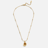 Leonie – Chain with circular pendant in gold.
